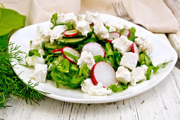 Salad with cheese and radishes in plate on board