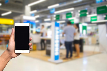 blurred photo and smartphone on shopping mall and people with bokeh.