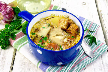 Soup fish with vegetables and croutons on light board