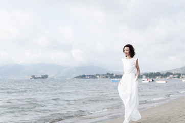 Fototapeta na wymiar Pregnant woman walking on the beach