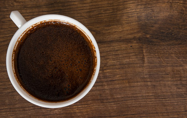 Cup of hot espresso coffee on wood table. top view. with copy space.