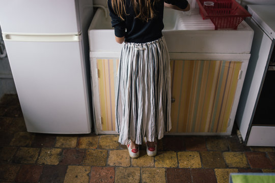 Fille face &agrave; l'&eacute;vier dans la cuisine 