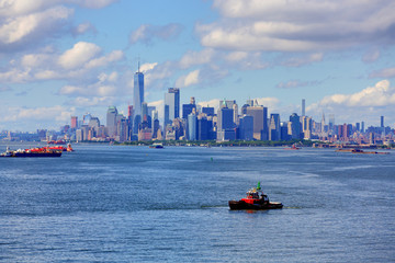 Naklejka premium Tugboat in Harbor with New York City in Background