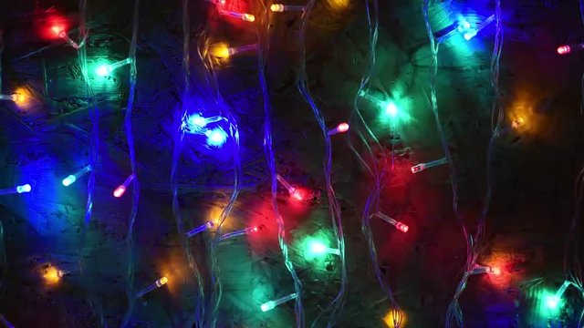 Multicolored blurred lights of a New Year's garland and flying soap bubbles as a background