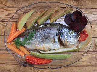 Fish dorado baked in the oven with vegetable garnish