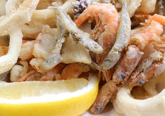 appetizing background of many fried fish with shrimp in a pan an