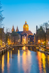 Fototapeta na wymiar Night in Amsterdam with the Basilica of St. Nicholas in Amsterdam city, Netherlands