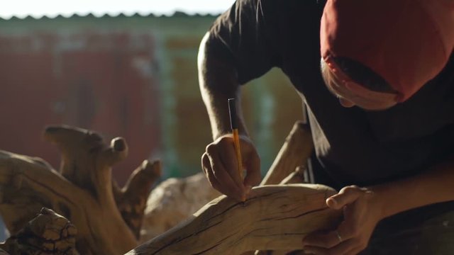 Man make a sketch for wood carving rapid slow motion