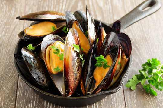 Mussels fried with garlic in a frying pan.