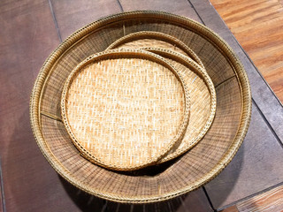Round Woven Bamboo Stripes Trays on a Wooden Plank Bench
