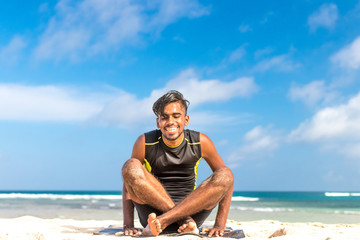 Fototapeta na wymiar Asian yoga man practice yoga on the beach with a clear blue sky background. Yogi on the tropical beach of Bali island, Indonesia.