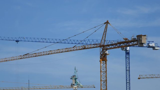 4k video of Crane moving construction panel with blue sky