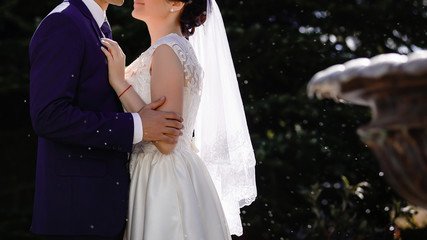 Young bride and groom in the park a wedding bouquet wedding dresses