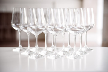 Crystal clear empty wine glasses on the table. Alcohol background. A lot of wine glasses at the bar.