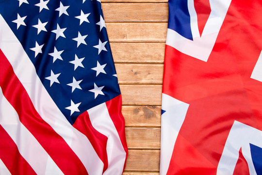 UK flag and USA Flag on wooden background.