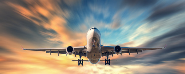 Obraz premium Samolot i piękne niebo z efektem rozmycia ruchu. Krajobraz z samolotem pasażerskim leci w niewyraźne błękitne niebo z żółtymi chmurami o zachodzie słońca. Samolot pasażerski. Samoloty komercyjne. Prywatny odrzutowiec