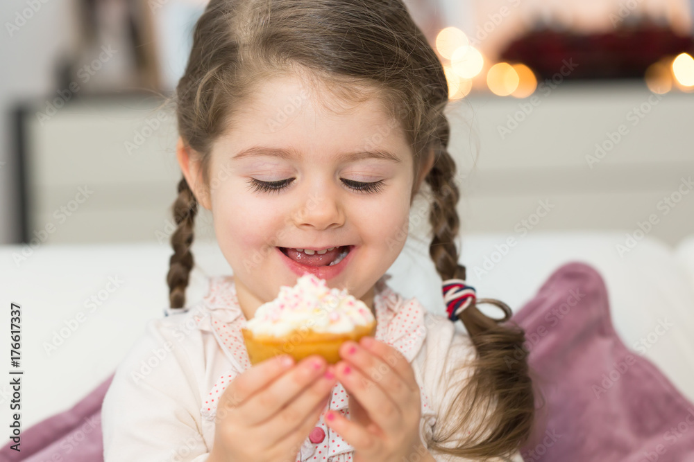 Wall mural cute girl eating muffin