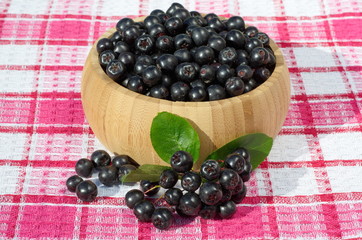 The Aronia berry in a bamboo bowl on the table