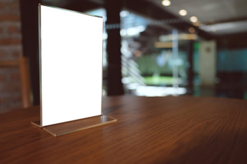 Mock up Menu frame standing on wood table in Bar restaurant cafe. space for text.