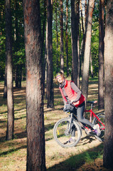 girl with a bicycle among the trees