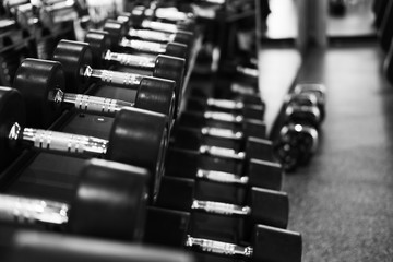 Row of dumbbells in gym. Black dumbbell set in sport fitness center.