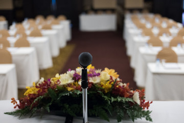 microphone in modern conference hall interior with white chairs. seminar room with empty seat. business event