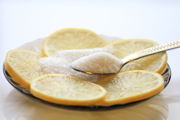 Appetizing lemon with slices and sugar, a teaspoon