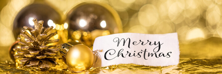 Merry Christmas Text in Englisch, Panorama in Gold mit Weihnachtskugeln