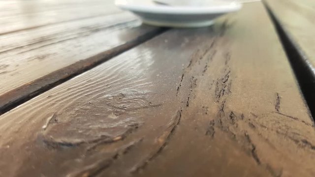 tazza di caffe su un tavolo, dietro persone sfocate 