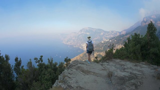 Italy. The Amalfi coast. A tourist on the edge of the cliff.