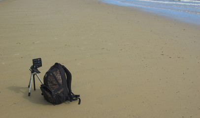 Camera bag and tripod with panoramic head on beach