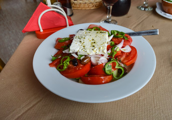 Plate of Greek salad with tomatoes, onions