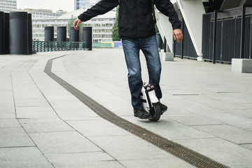 man on self balancing one wheel scooter in the city