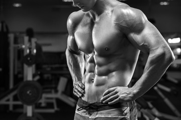 Handsome muscular man abs in gym, shaped abdominal. Strong male torso, working out