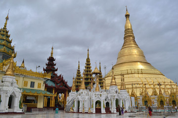 Naklejka premium The national religious symbol of Burmese. It's the shwedagon Pagoda with its golden stupa, and many people visiting this place