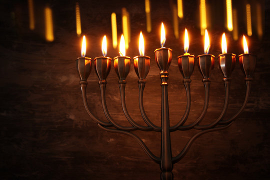 Low key image of jewish holiday Hanukkah background with menorah (traditional candelabra) and burning candles