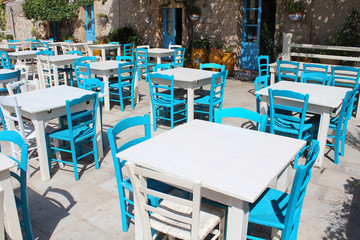 Fototapeta na wymiar Marzameni (Sicile) / Terrasse de restaurant avec tables et chaises en bois
