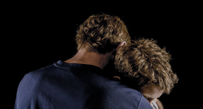 Moody shot, father comforting son after argument