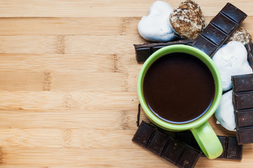 Cup of cocoa with chocolate and gingerbread top view on wooden background