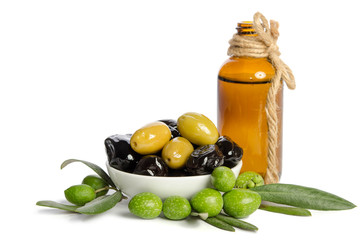 Black and green  olives  mixed in the  porcelain bowl and Virgin olive oil in a crystal bottle isolated on white background