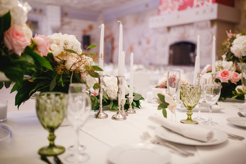 Table decor with white flowers and candles for a wedding party