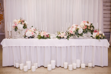 Table decor with white flowers and candles for a wedding party