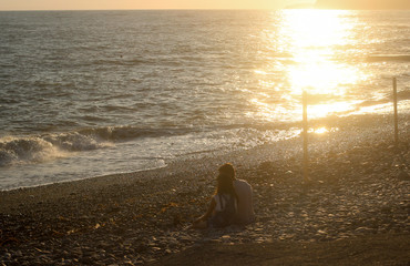 people on the seafront, a couple of people sitting on the coast, sunset on the sea, loving people, the rest of the sea, people on the beach