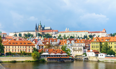 Fototapeta premium Prague Castle. The Charles Bridge. Medieval fortress. The Vltava River. Red tiled roofs. View from Charles Bridge