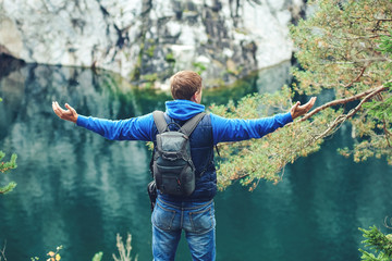 Man enjoying beautiful lake view at a canyon. He is holding his arms wide open.