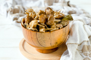 Marinated mushrooms (honey agarics) in a wooden bowl