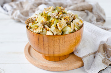 Salad of chicken, potatoes, pickled mushrooms and pickles with parchment from Dijon mustard