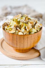 Salad of chicken, potatoes, pickled mushrooms and pickles with parchment from Dijon mustard