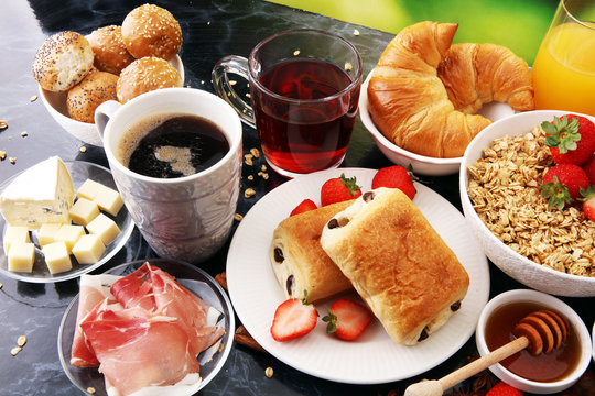 Breakfast served with coffee, orange juice, croissants and strawberry, jam and tea.