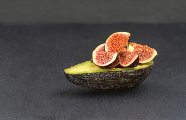 Frische Avocado und Feigen auf schwarzem Grund